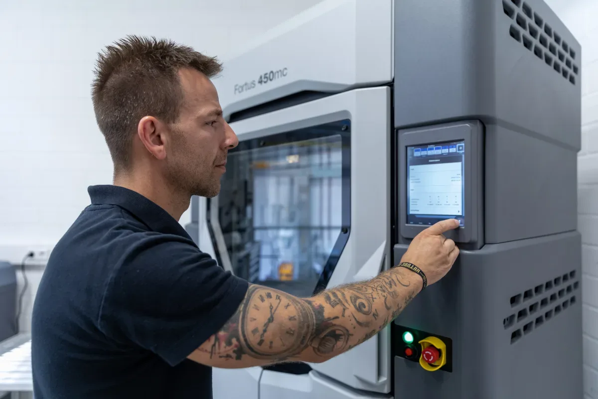 Machine operator loading a job at the control panel